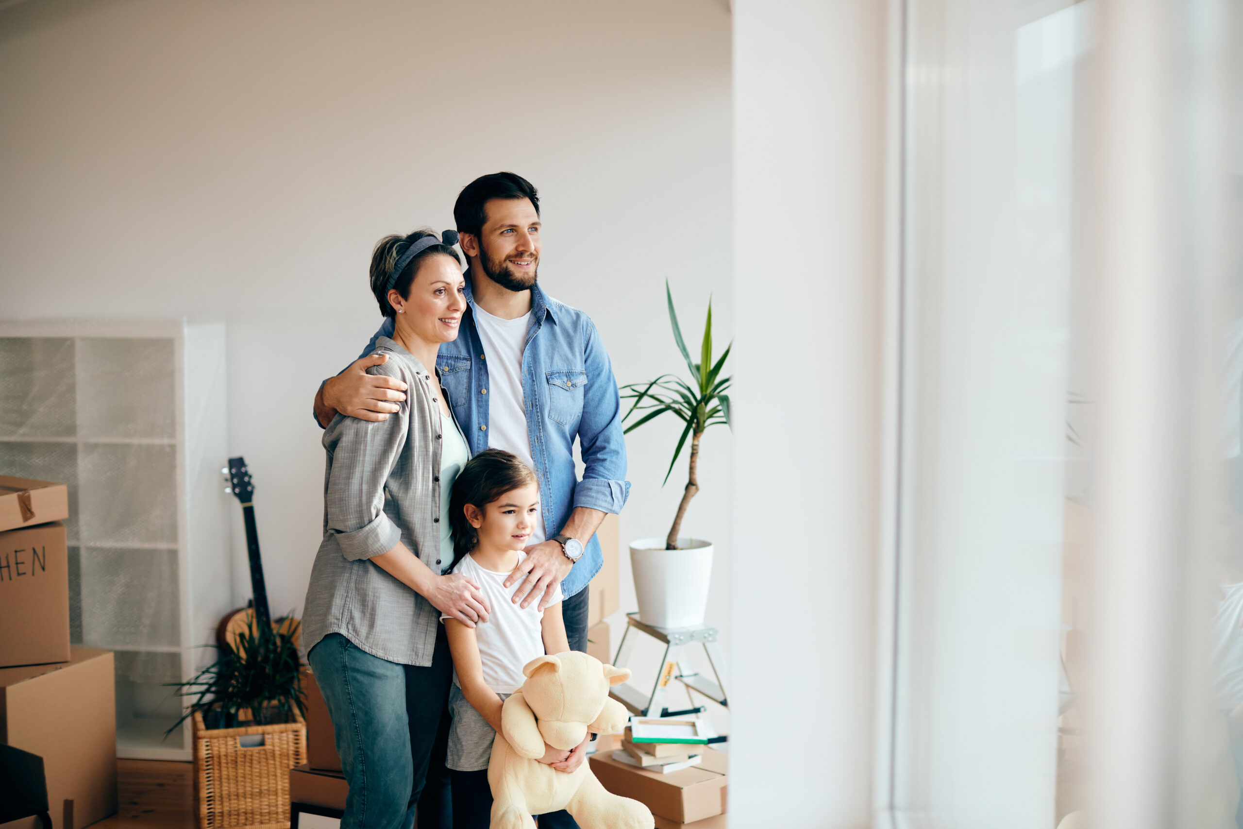 Happy Family Looking Through Window While Moving Into New Home Scaled
